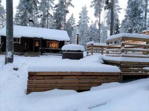 Cabaña de madera con chimenea en la nieve en Unique winter holiday in pine forest, en Forssa