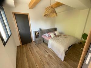 - une chambre avec un lit dans un dortoir doté de parquet dans l'établissement six fours les plages logement maison, à Six-Fours-les-Plages