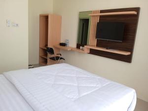 1 dormitorio con 1 cama blanca y TV de pantalla plana en Ni_Er Guesthouse by Mr.Tsabalala, en Panjunan