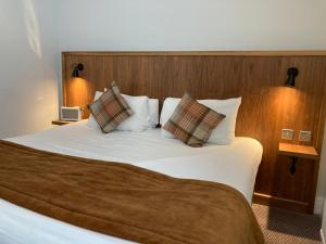 a bedroom with a large white bed with two pillows at The Cross-Keys Hotel in Knutsford