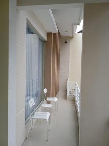 pasillo con sillas blancas y ventana en Ni_Er Guesthouse by Mr.Tsabalala, en Panjunan