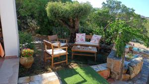 a patio with two chairs and a couch and a table at I Mari Di Gallura Suites and Rooms in San Teodoro