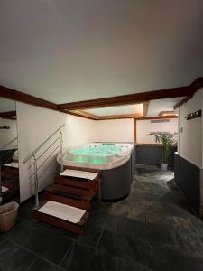 a large bath tub in a room with a staircase at Hotel Athena in Brides-les-Bains