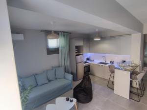 a living room with a couch and a kitchen at Niriides Apartments in Porto Heli