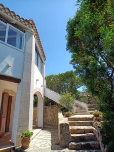 a house with a staircase leading up to a building at I Mari Di Gallura Suites and Rooms in San Teodoro