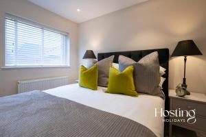 1 dormitorio con 1 cama grande con almohadas amarillas en The Oars Apartment - Marlow - Parking Included en Marlow