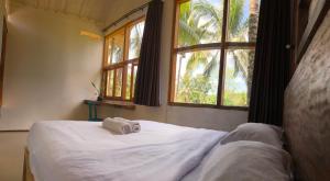 a bedroom with a bed with two towels on it at Mu Homestay in Tetebatu