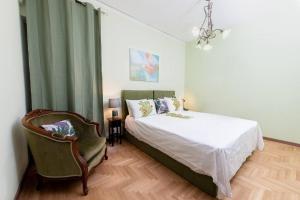 um quarto com uma cama, uma cadeira e um lustre em The House οf Abunance near Downtown em Atenas