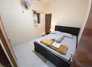 سرير أو أسرّة في غرفة في Marry Ind Gunung Kawi Guest House Malang