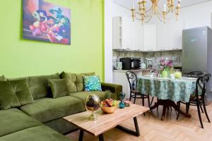 uma sala de estar com um sofá verde e uma mesa em The House οf Abunance near Downtown em Atenas