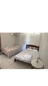 - une chambre avec 2 lits jumeaux et une table dans l'établissement Aconchego em Parnaiba jw, à Parnaíba