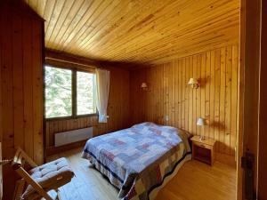 1 dormitorio con 1 cama en una cabaña de madera en L'Ecrin des neiges, en Camprieu