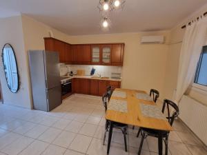 a kitchen with a wooden table and a refrigerator at AApartment, Nea Peramos in Nea Peramos