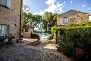 グラダーラにあるCastello di Granarola - Dimora storica, Suites e Appartamentiの庭にスイミングプールがある石造りの家