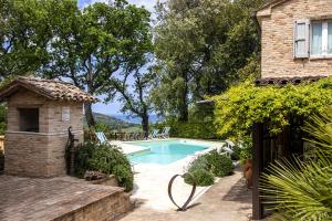 una piscina di fronte a una casa di Castello di Granarola - Dimora storica, Suites e Appartamenti a Gradara