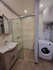 a bathroom with a sink and a washing machine at AApartment, Nea Peramos in Nea Peramos