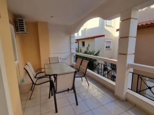 a balcony with a table and chairs on a building at AApartment, Nea Peramos in Nea Peramos