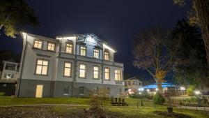 ein großes Gebäude mit Lichtern in der Nacht in der Unterkunft Ostseehotel Villen im Park - ein Rovell Hotel in Bansin