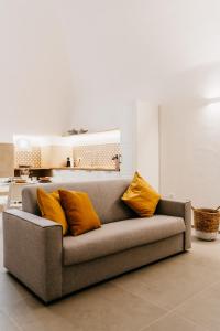 - un canapé avec deux oreillers orange dans l'établissement Dal Monaco - casa vacanze, à Castellana Grotte