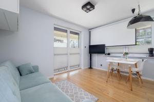 ein Wohnzimmer mit einem Sofa und einem Tisch in der Unterkunft Osiedle Życzeń Apartment Stawowa Cracow by Renters in Krakau