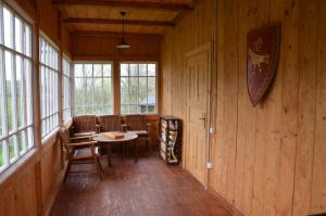 a room with a table and chairs and windows at Вершище in Urych