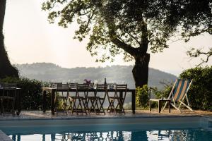 een tafel en stoelen naast een zwembad bij Castello di Granarola Relais in Gradara