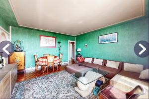 a living room with a couch and a table at Chambre dans appartement chez habitants À côté du Lac et du Casino in Épinay-sur-Seine