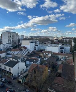 een uitzicht op een stad met gebouwen en een bewolkte lucht bij Chambre dans appartement chez habitants À côté du Lac et du Casino in Épinay-sur-Seine