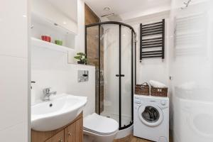 łazienka z umywalką i pralką w obiekcie Czarnowiejska Mini Studio w Krakowie