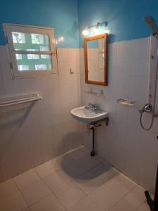y baño con lavabo y espejo. en KONE-METTLER GUEST HOUSE en Abémé