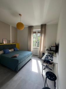 um quarto com uma cama azul, uma secretária e uma janela em MARGHERITA DI PARMA em Parma
