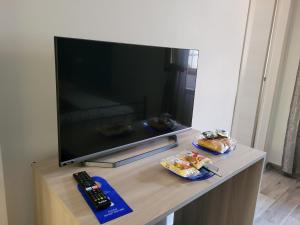 a television sitting on a table with a remote control at Rooms da Pisicchio in Fiumicino