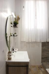a white bathroom with a sink and a window at Casa de la Alegría in Granada