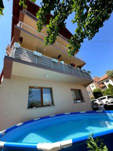 a house with a swimming pool in front of a building at Apartman Ejna in Sarajevo