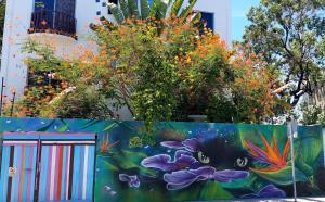 un mural de flores en una pared junto a una valla en Vainilla Bed and Breakfast Mexico, en Playa del Carmen