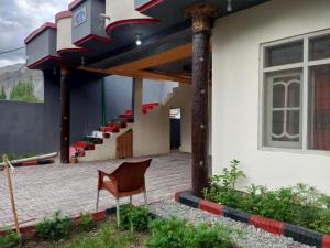 una silla sentada frente a un edificio con escaleras en Stream View Guest House, en Skardu