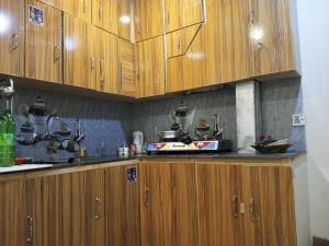 a kitchen with wooden cabinets and a counter top at Stream View Guest House in Skardu