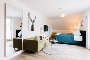 Zimmer mit einem Bett, einem Sofa und einem Spiegel in der Unterkunft New Living City Appartement in Bielefeld