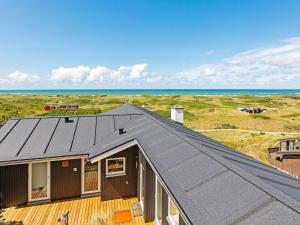ein Dach eines Hauses mit dem Ozean im Hintergrund in der Unterkunft 6 person holiday home in L kken in Løkken