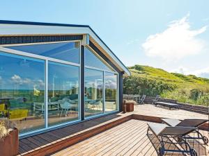 ein Haus mit Glasschiebetüren auf einer Terrasse in der Unterkunft 6 person holiday home in L kken in Løkken