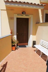 un banco sentado frente a un edificio con una puerta en Piccola Perla Guest House, en Valmontone