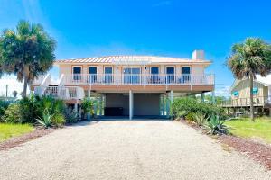 a large house with palm trees and a driveway at Island Charm in St. George Island