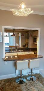 Una cocina con encimera, fregadero y espejo. en Seaview Apartment Sleeps 2 -Patio -WiFi -Tv, en Barmouth