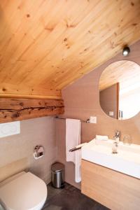 ein Badezimmer mit einem weißen Waschbecken und einem Spiegel in der Unterkunft La Ferme du Lignon in Genf