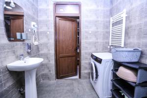 a bathroom with a sink and a washing machine at Tbilisi Tower Apartment in Tbilisi City