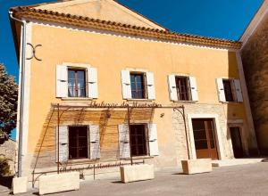 un vecchio edificio con finestre bianche ai lati di L’auberge de Montsalier a Le Plan