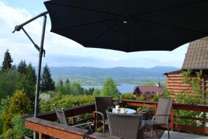 a patio with a table and chairs and an umbrella at Uroczy domek letniskowy. in Falsztyn
