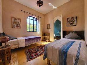 a bedroom with two beds and a window at Dar janoub in El Jadida
