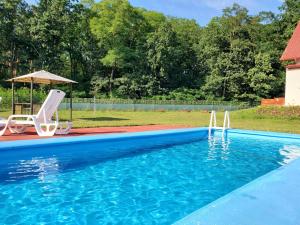a swimming pool with two chairs and an umbrella at OK Relax in Rybaki