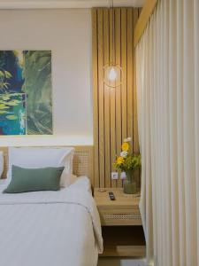a bedroom with a bed and a table with flowers at Cozy Jogja in Kejayan